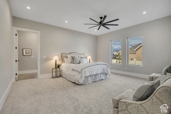 Recessed lighting, a modern ceiling fan, two windows, and light gray wall finishes