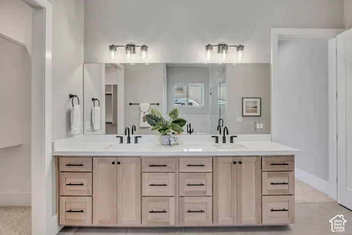 Dual-sink vanity with wood-finish cabinetry, white quartz countertop, and matte black hardware