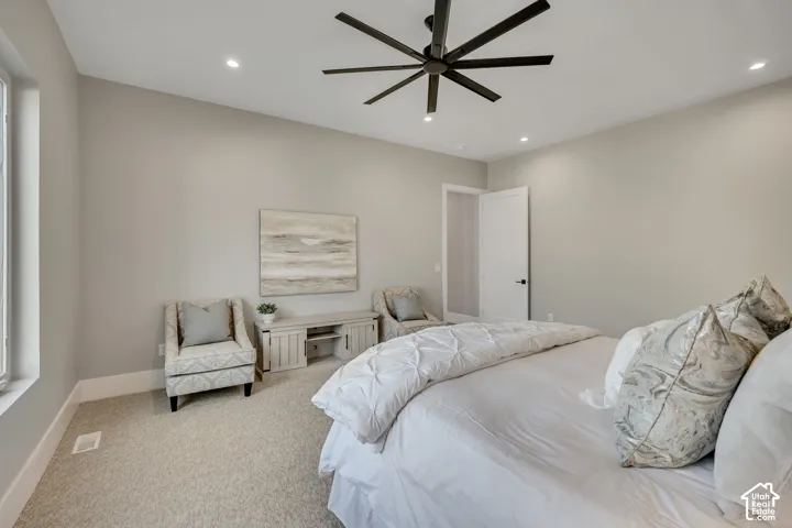 Recessed lighting, contemporary ceiling fan, light-colored walls, window with trim, light-colored carpeting
