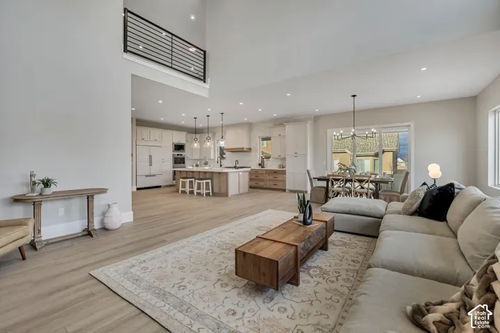 Open-concept living area featuring high ceilings, wood-finish flooring, and recessed lighting