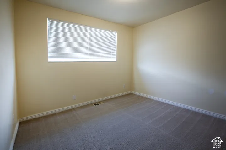 Carpeted flooring, neutral wall tones, baseboard trim, window with blinds, and ceiling-mounted lighting