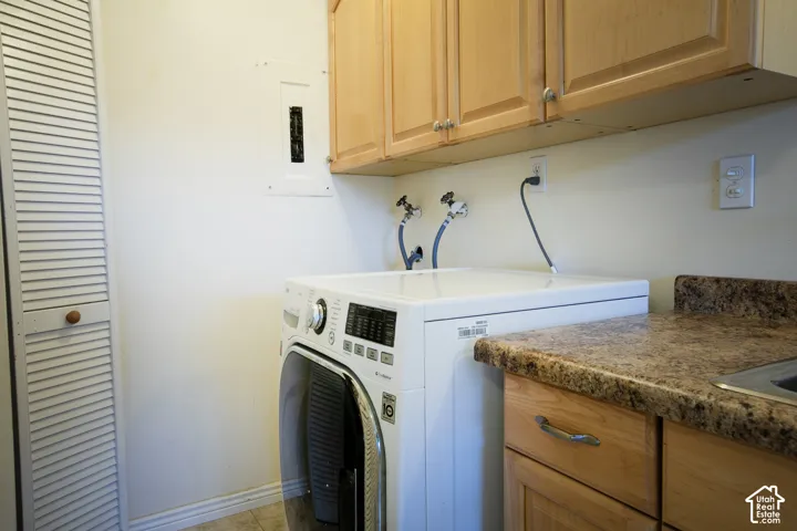 Wood-finish cabinetry, speckled countertop, and built-in sink