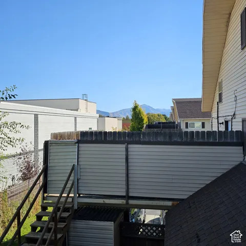 Outdoor stairs with wood railing, leading to an elevated deck