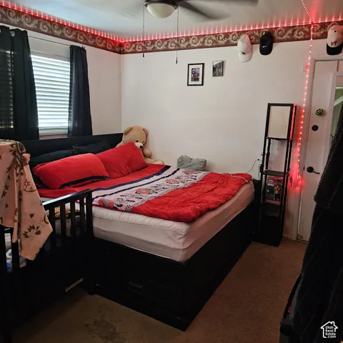 Wall-to-wall carpeting and a ceiling fan with integrated lighting