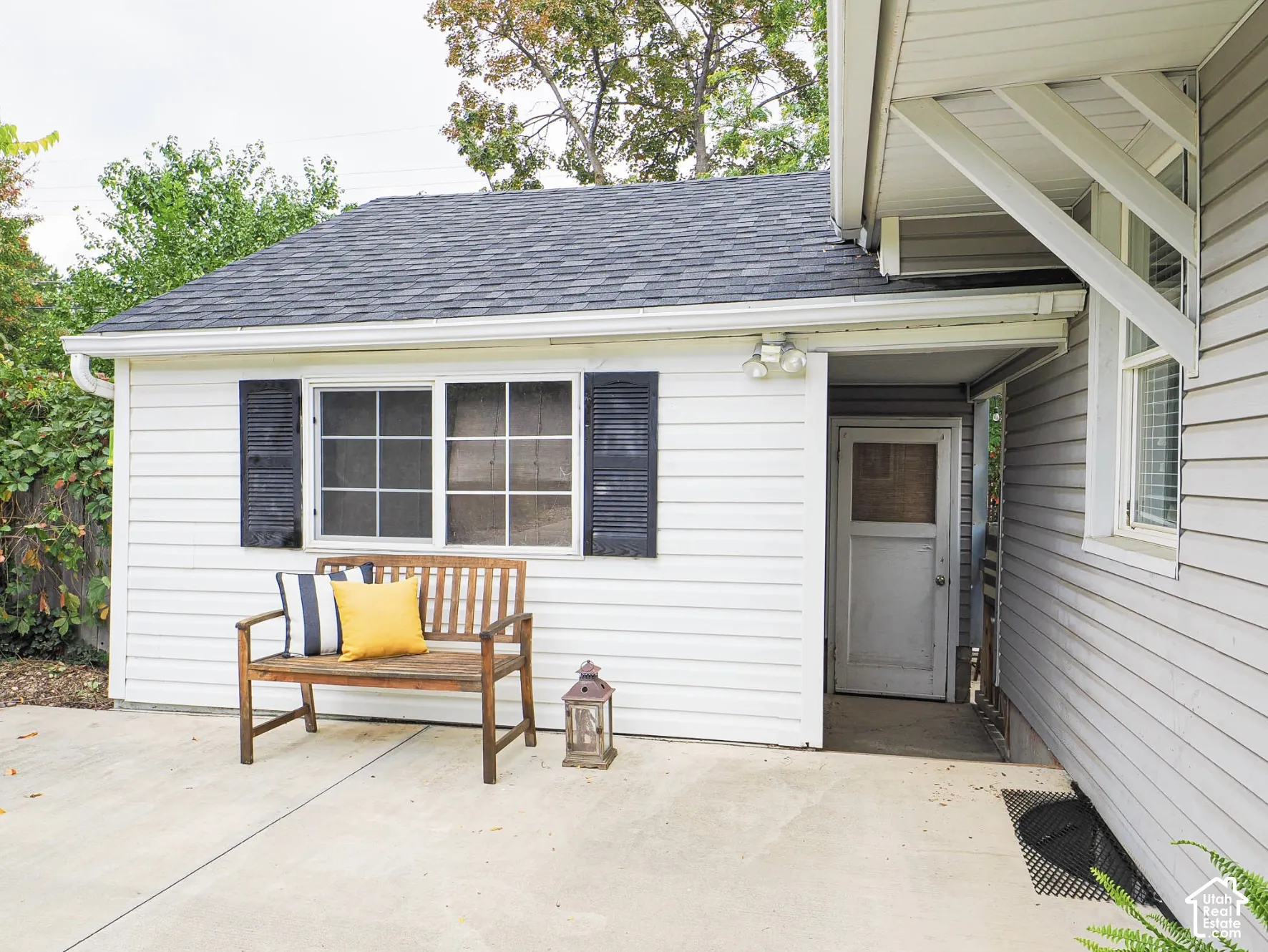 White horizontal siding exterior with dark gray shingle roofing