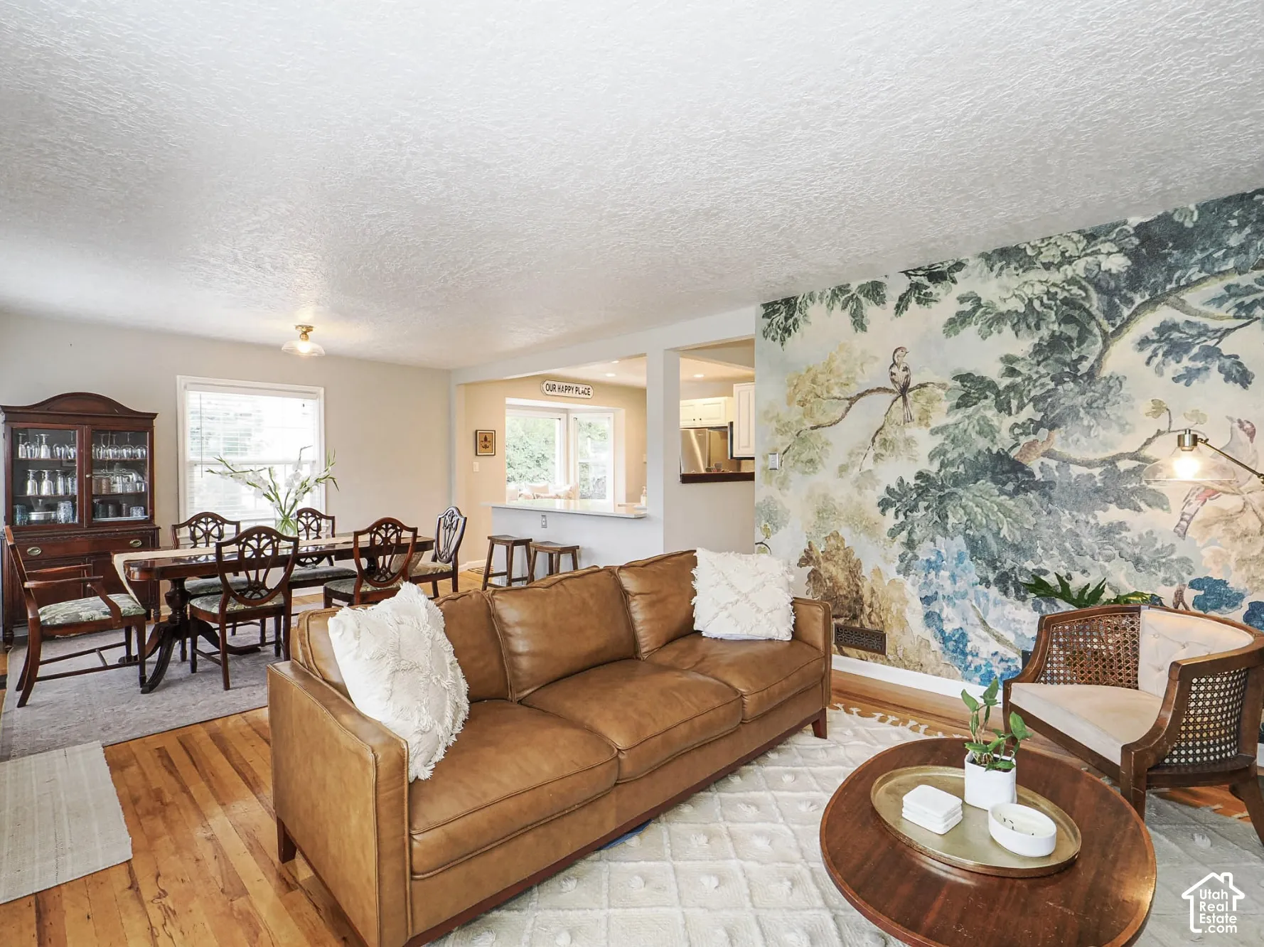 Hardwood flooring throughout, recessed lighting, and a detailed mural wall