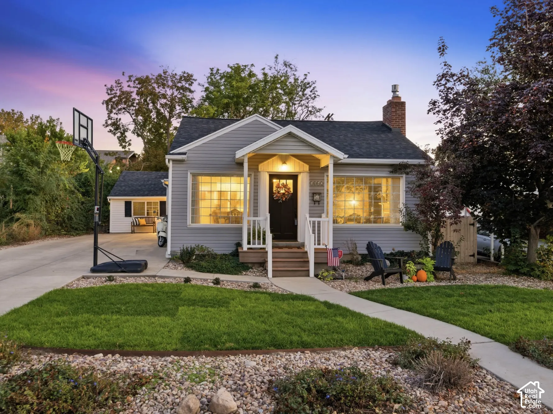 Siding exterior with a covered front porch, concrete pathway, and manicured lawn