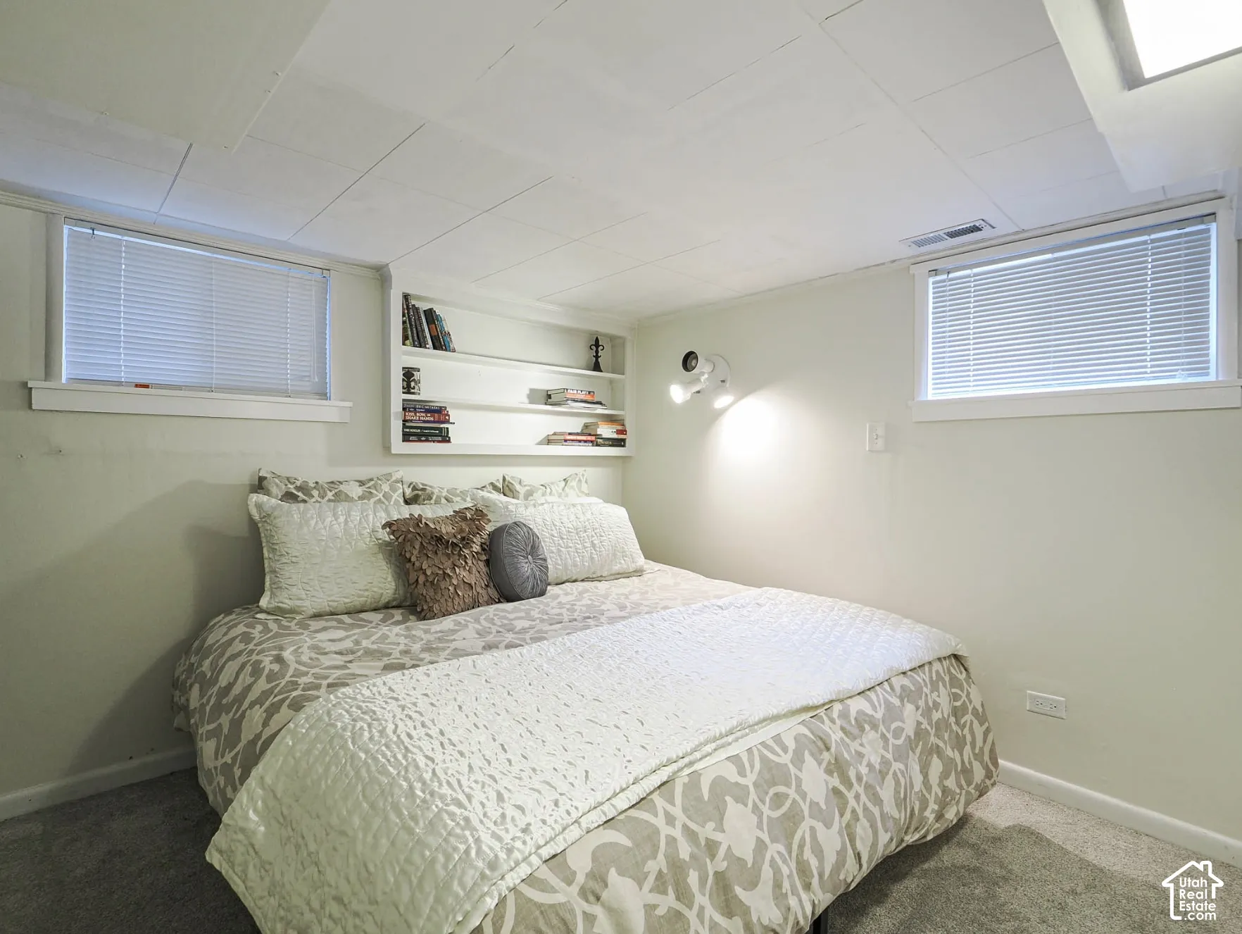 Recessed ceiling panels with built-in shelving, dual-window configuration, and wall-mounted track lighting