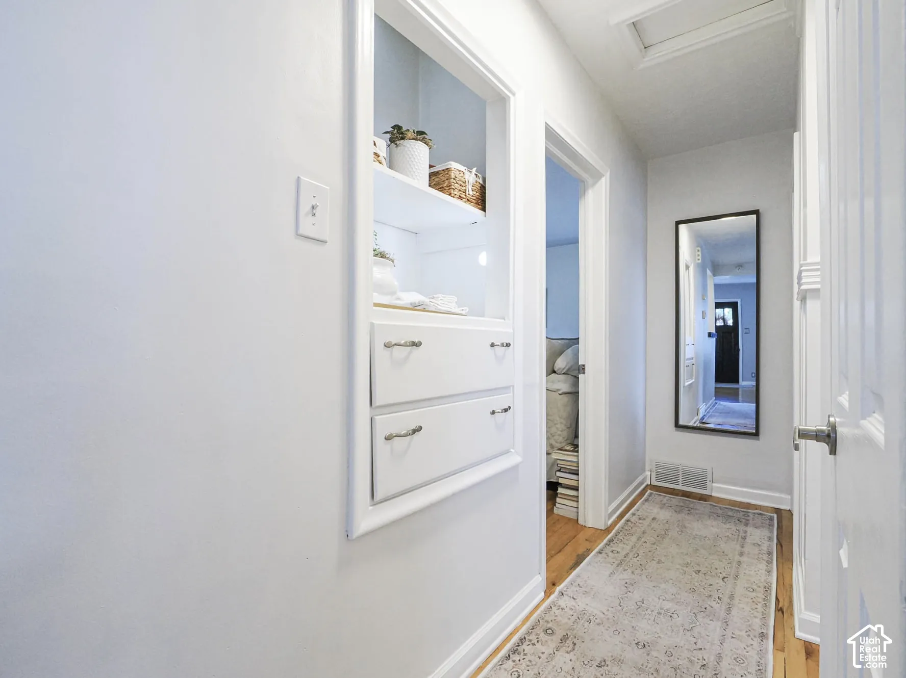 Built-in shelving with integrated drawers, wood-finish flooring, and white trim