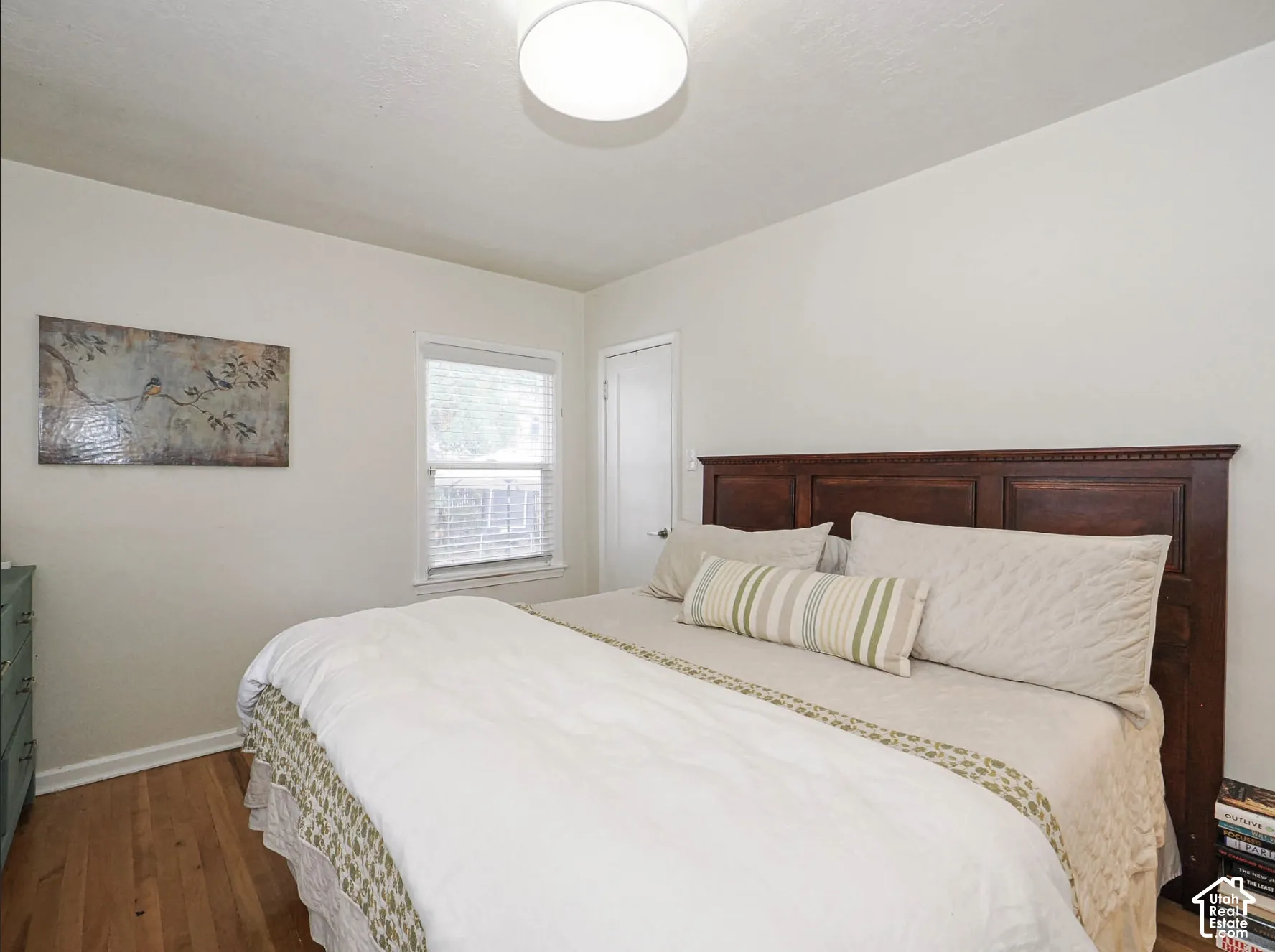 Hardwood flooring, single window with blinds, and white walls