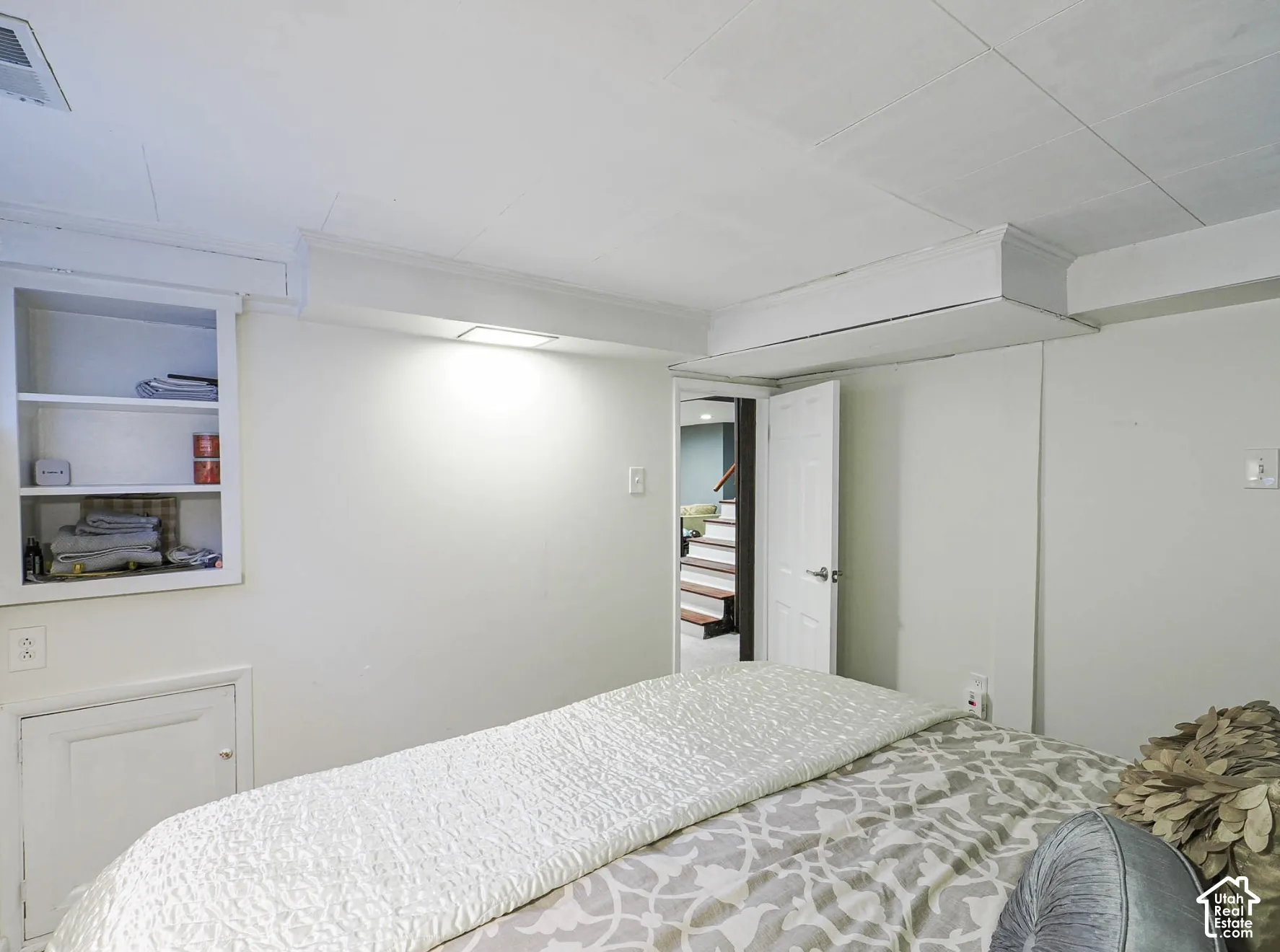 Built-in wall shelving and enclosed lower cabinet, recessed lighting, and white paneled door