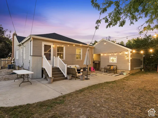 Backyard patio featuring concrete surfacing, a multi-level deck with white railings, and a detached structure with siding