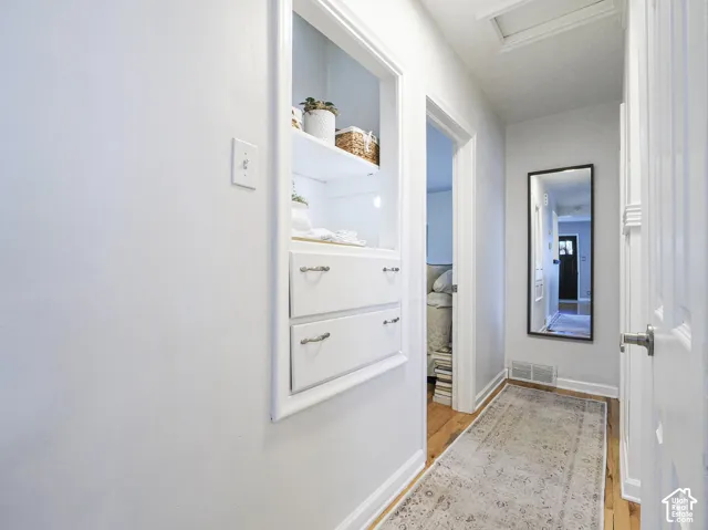 Built-in shelving with integrated drawers, wood-finish flooring, and white trim