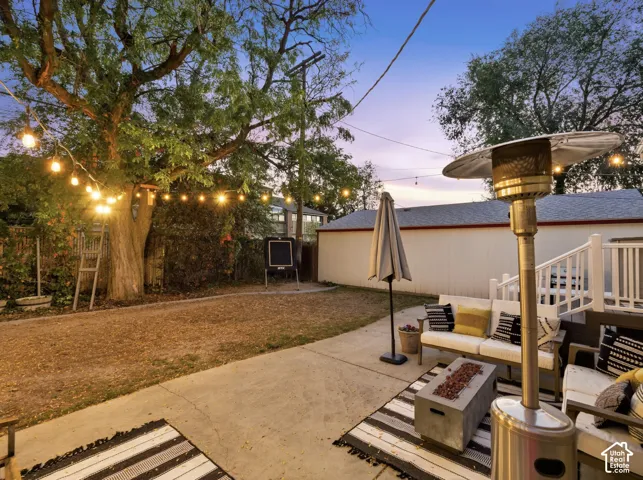 Expansive concrete patio with string lighting and a built-in deck