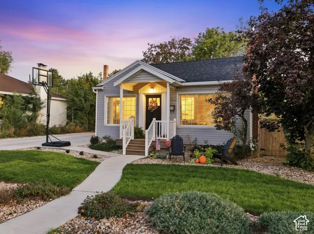 Well-manicured front yard with green lawn, concrete pathway, and mature landscaping