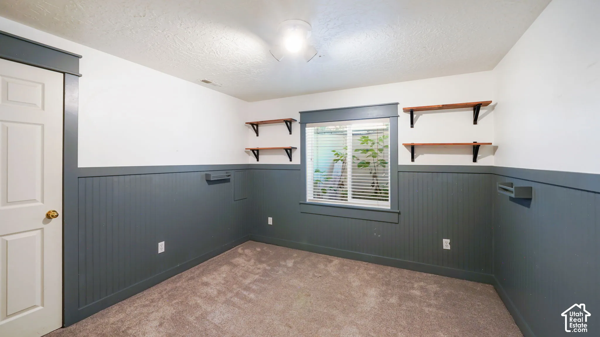 Beadboard wainscoting with a contrasting upper wall, integrated shelving, and a window with blinds
