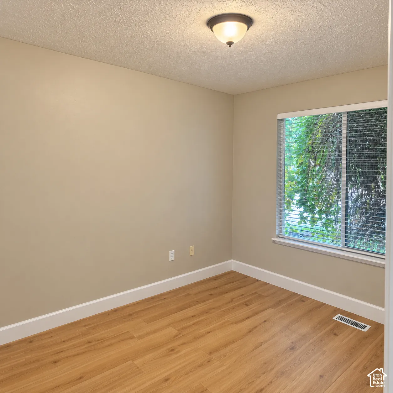 Wood-finish flooring, neutral wall tones, white trim, and a window with blinds