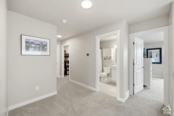 Light gray carpeting in a hallway with recessed lighting