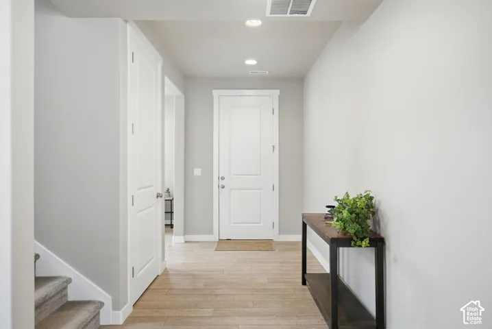 Recessed ceiling lighting, light wood-finish flooring, and white trim throughout