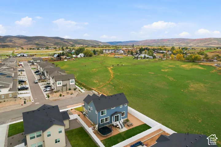 Blue exterior with white trim, private fenced backyard, and a paved patio area