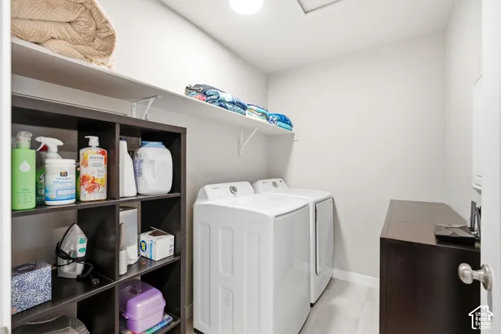 Utility space featuring built-in shelving, wall-mounted shelving, and wood-finish flooring