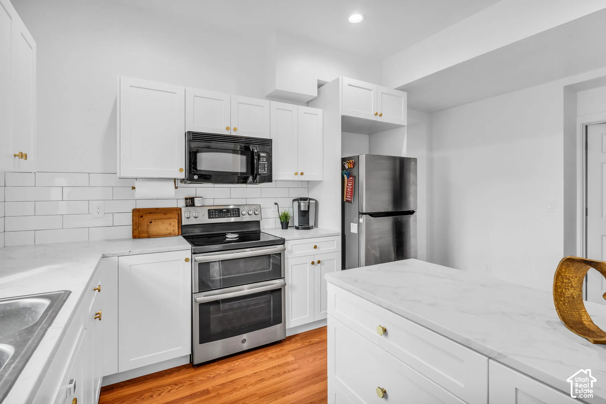 White shaker cabinetry with gold-finish hardware