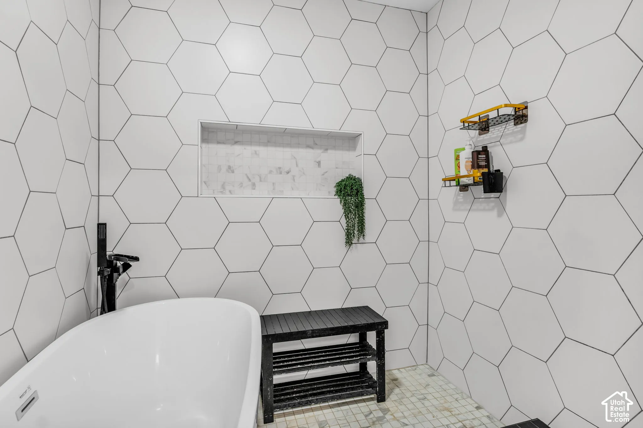 Freestanding soaking tub with a matte black floor-mounted faucet