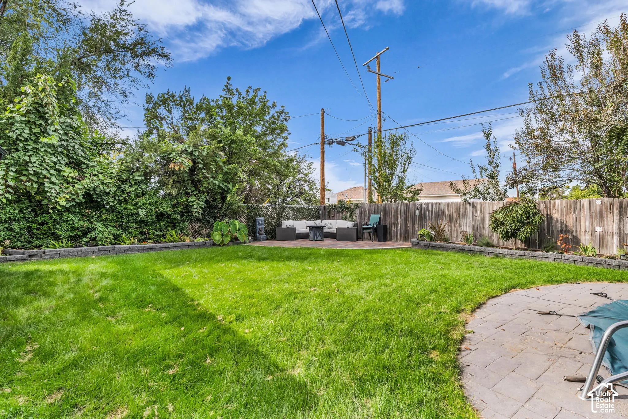Expansive green lawn with a paved patio area