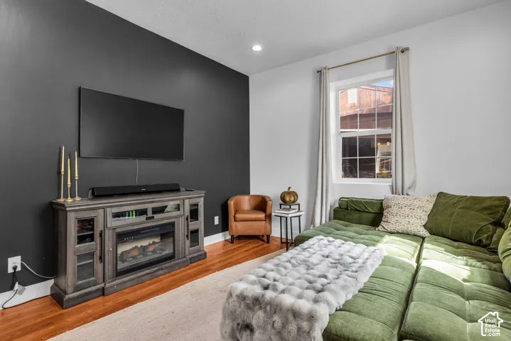 Hardwood-finish flooring, recessed lighting, and a built-in media console with an electric fireplace