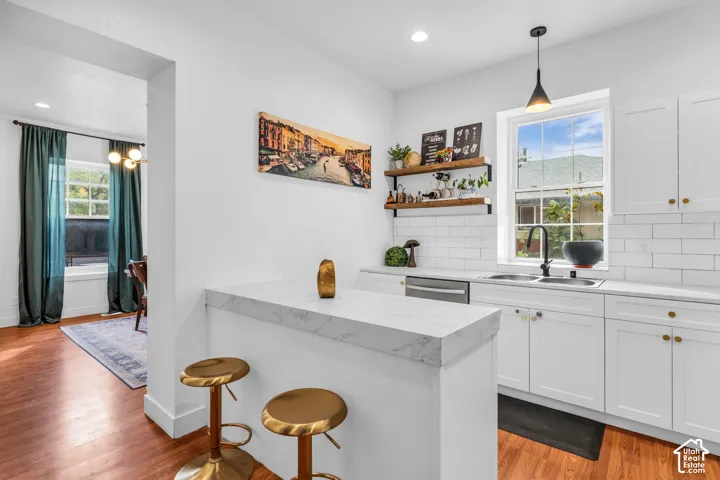 Kitchen featuring white cabinetry, subway tile backsplash, white countertops, and a stainless steel dishwasher