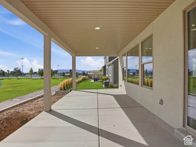 Covered patio featuring recessed lighting, a concrete slab, and an adjacent green space