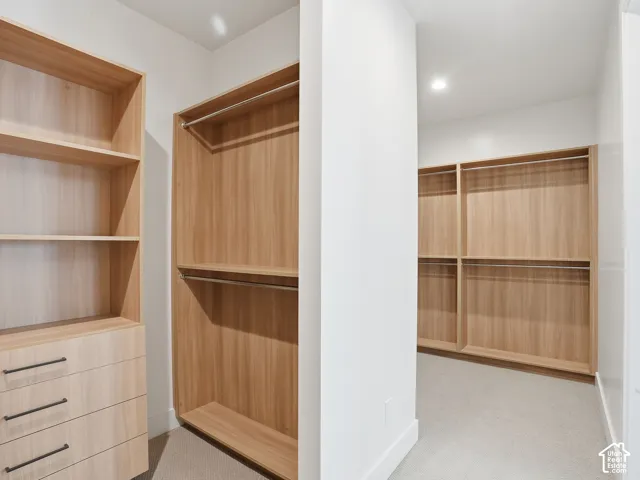 Built-in custom closet system featuring wood-finish shelving, integrated drawers with dark hardware, and multiple hanging rods