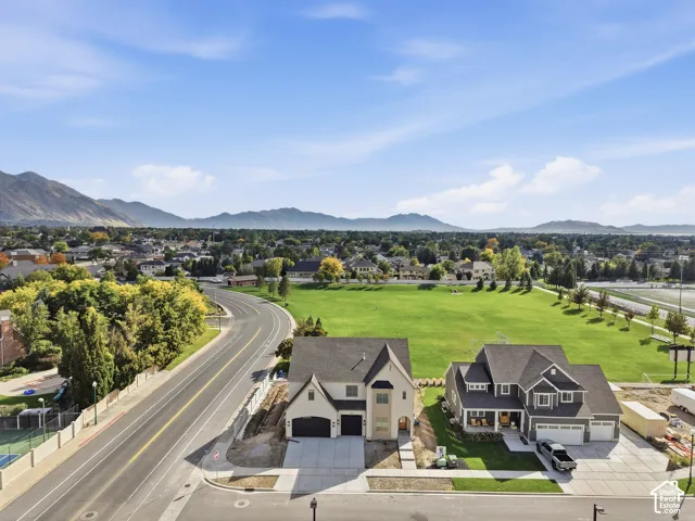 Expansive neighborhood setting with mountain backdrop and green spaces