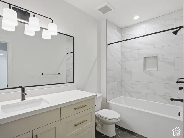 Contemporary bathroom featuring a black-framed mirror, dual-sink vanity with quartz countertop, and a tiled tub surround with an integrated niche