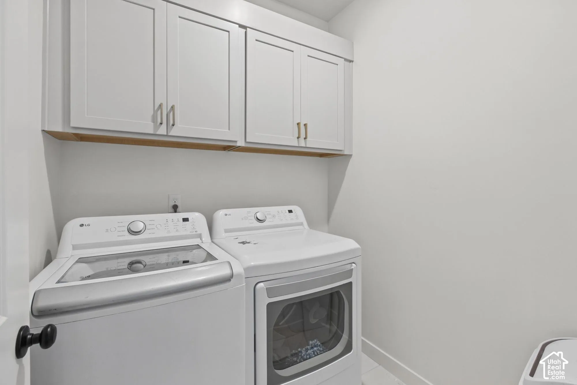 White shaker-style cabinetry with gold-tone hardware