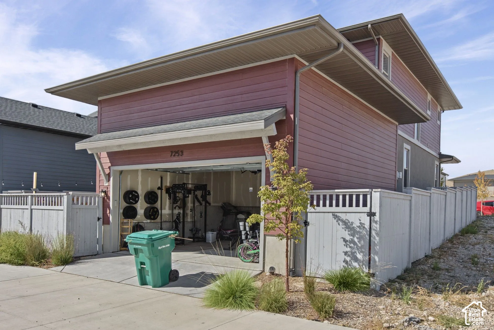 Attached two-car garage with overhead door, and red horizontal siding exterior