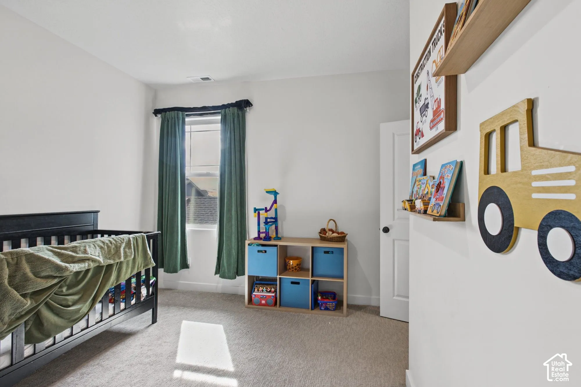 Carpeted flooring, white walls, and a window with a dark rod