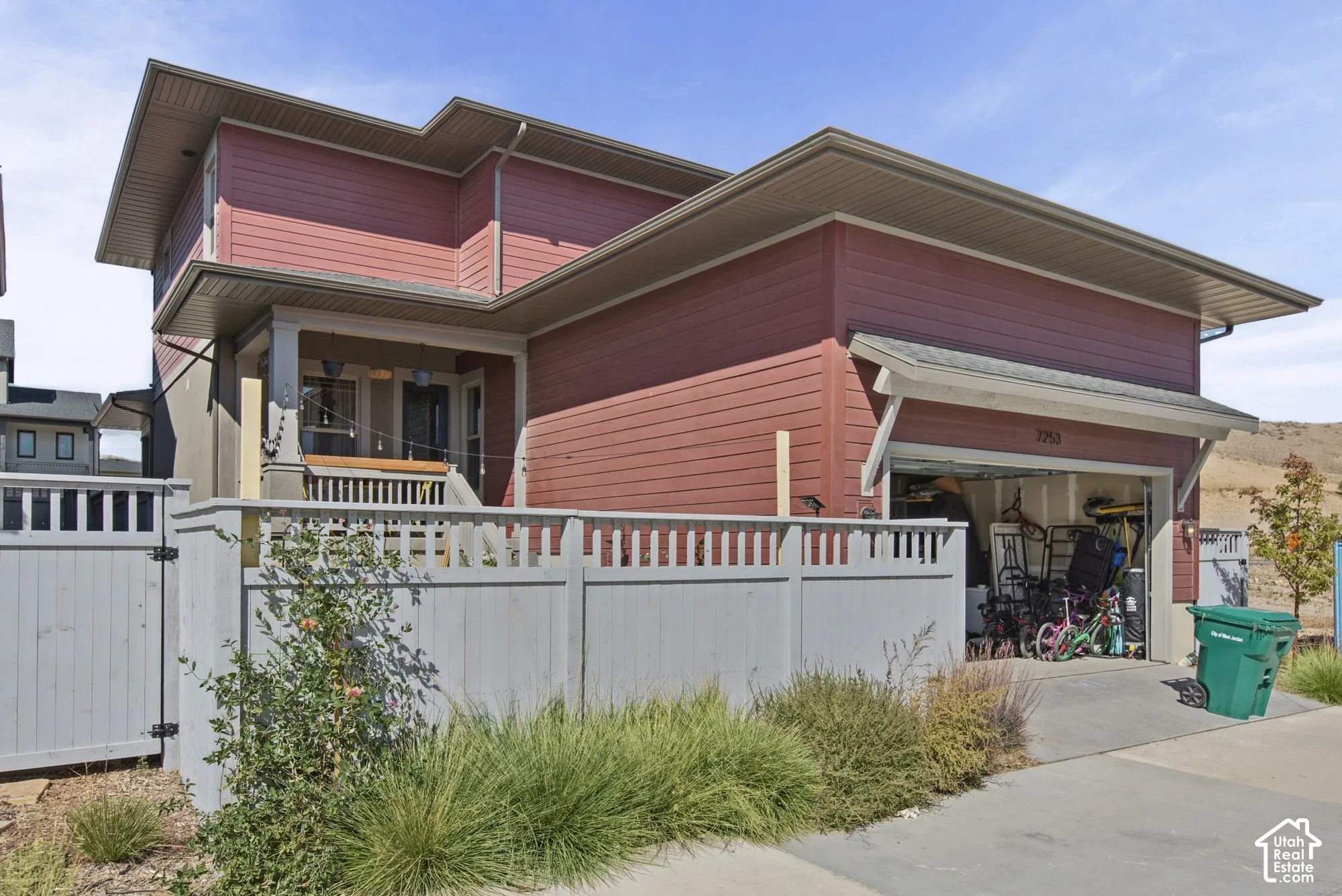 Red siding exterior with an attached single-car garage and a paved driveway