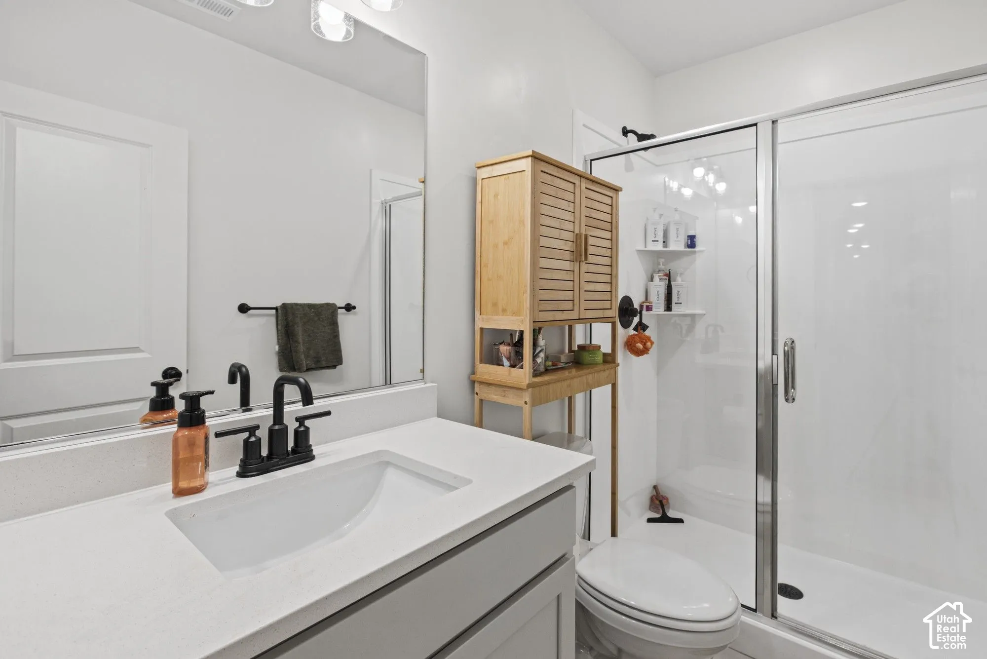 Vanity with integrated sink, black-finish faucet, and full-width mirror