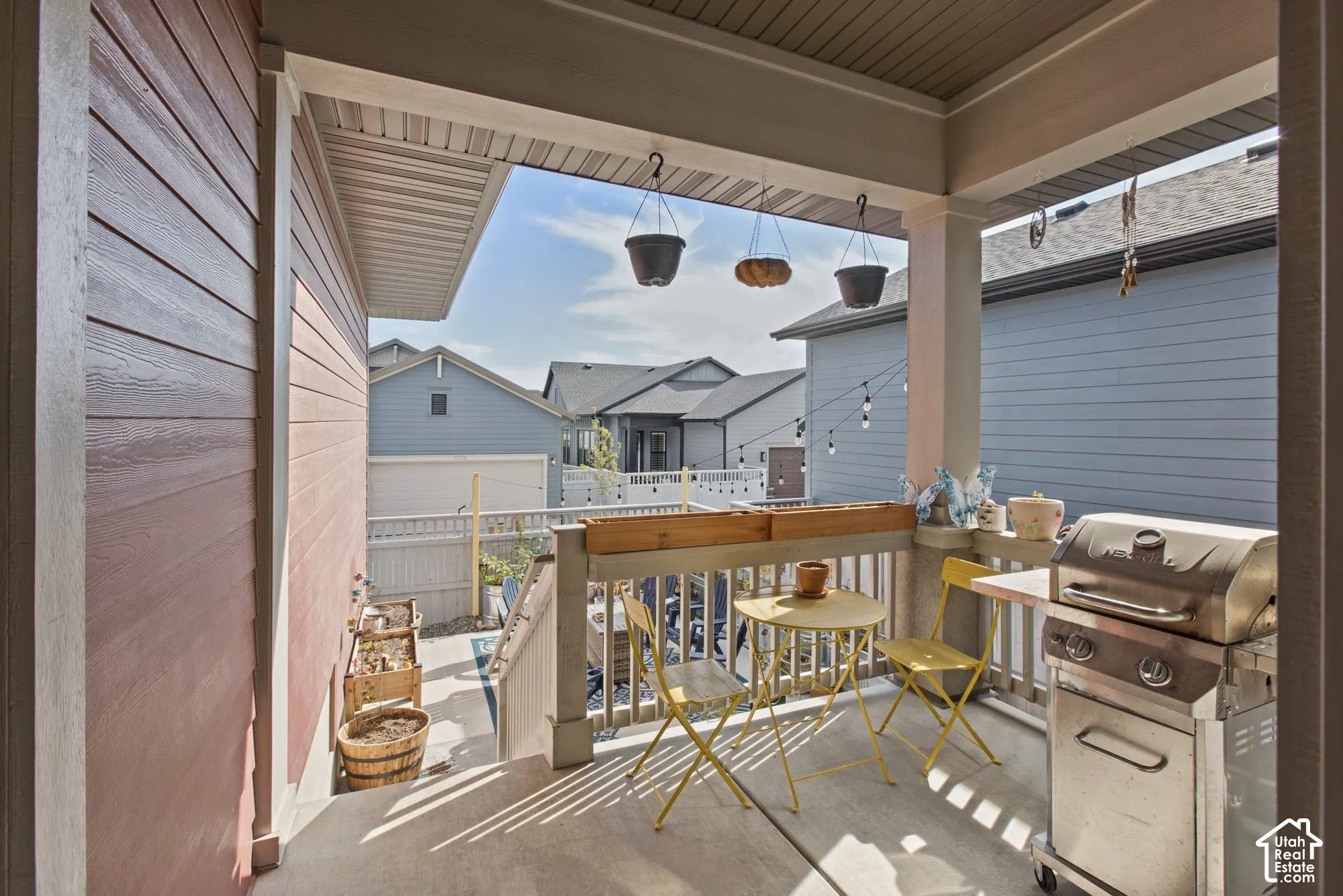 Covered outdoor patio with a concrete floor, white railing, and exterior siding