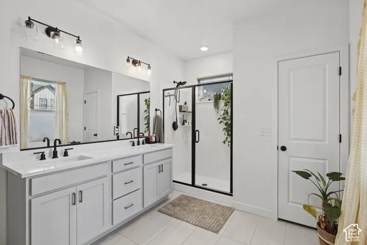 Dual vanity with white countertops, matte black faucets, and light-colored cabinetry