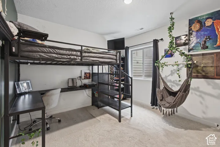 Built-in loft bed with integrated shelving and desk workspace, recessed lighting, and a window with horizontal blinds