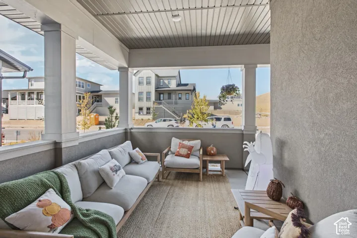 Covered porch with substantial columns, textured exterior wall finish, and a slatted ceiling