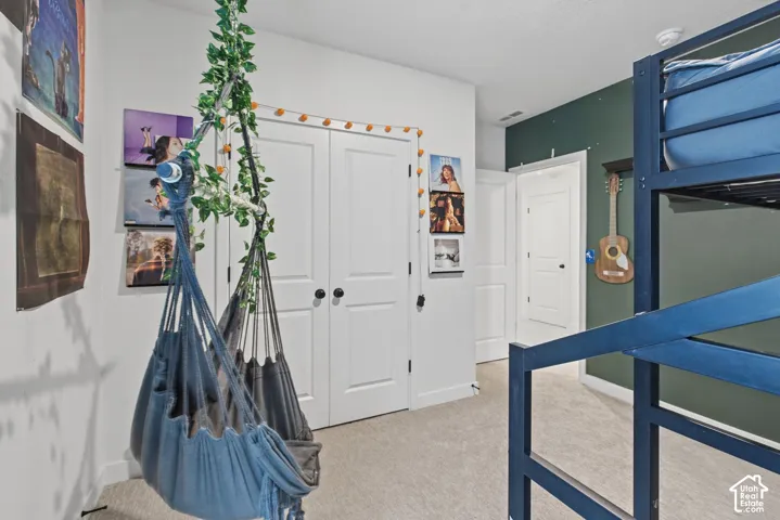 Carpeted flooring, white trim, and a dark green accent wall