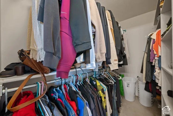 Walk-in closet featuring multiple shelving units and clothing rods