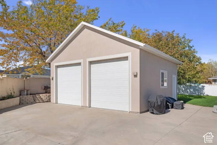 Two-car detached garage with stucco exterior, a side entry door, and a single window
