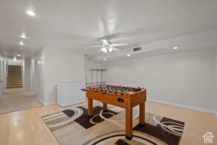 Recessed lighting throughout, ceiling fan with light fixture, light wood-finish flooring, and built-in shelving
