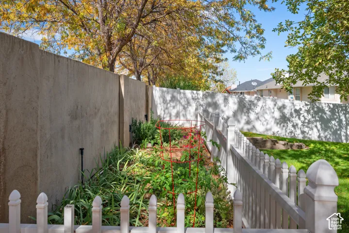 Manicured lawn with mature trees and a white picket fence