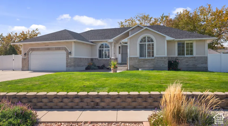 Stucco exterior with stone veneer accents, arched windows, and an attached garage