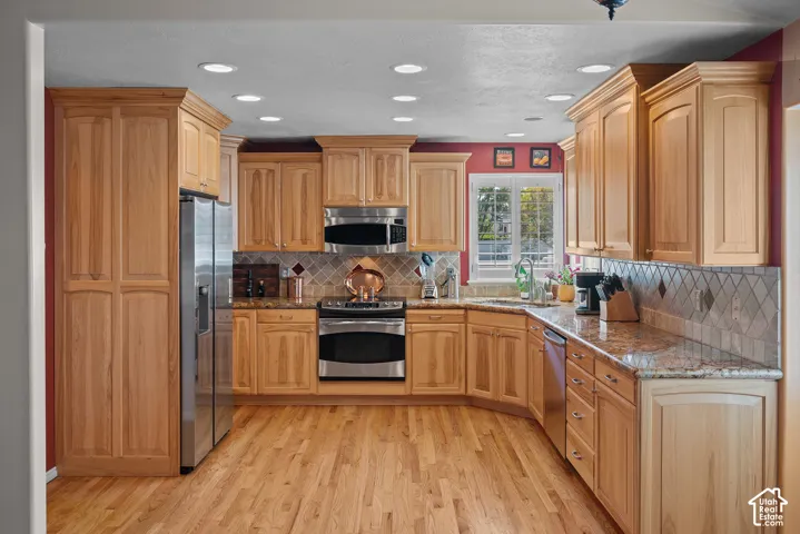Recessed lighting illuminates wood-finish cabinetry and flooring